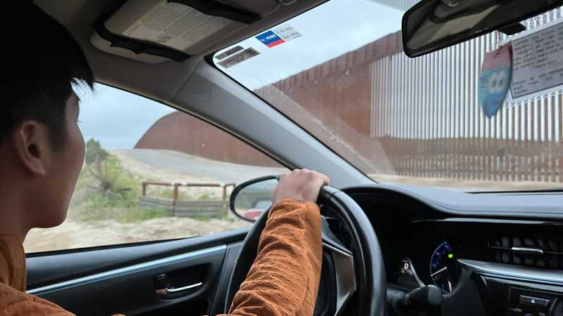 Driving by the border wall on the way to the terminus